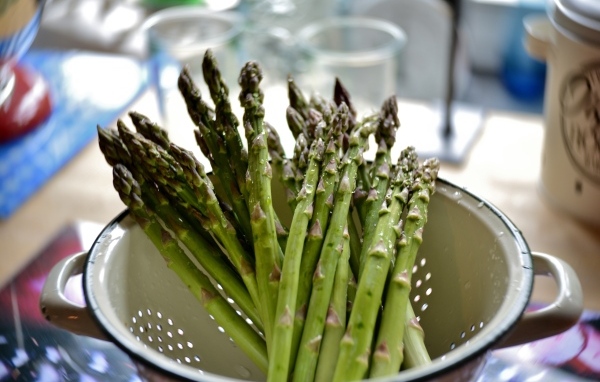 Зеленые стебли спаржи в кастрюле