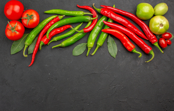 Острый перец чили на столе с помидорами