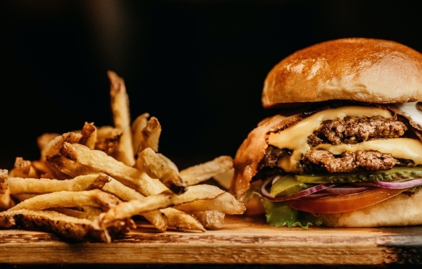 Сочный гамбургер на столе с картофелем фри