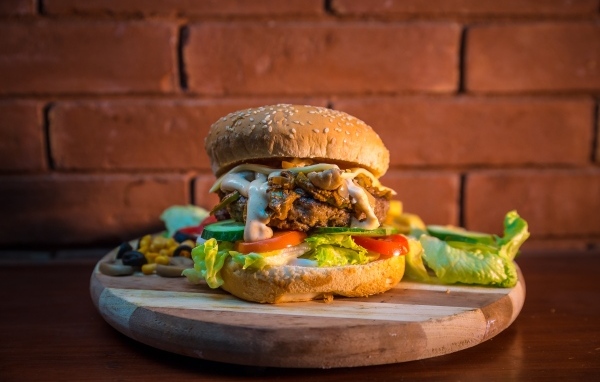 Большой аппетитный гамбургер на фоне стены