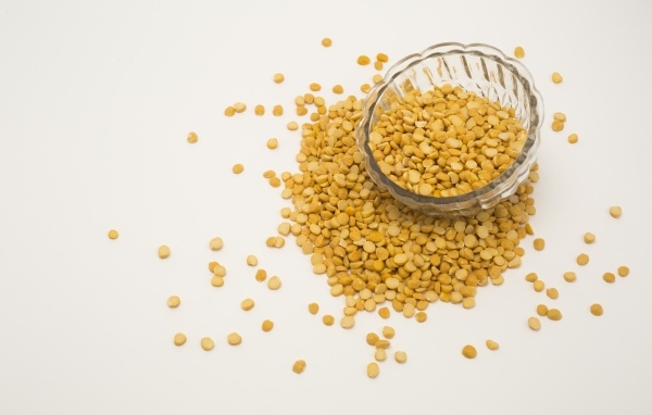 Чечевица рассыпана на белом фоне