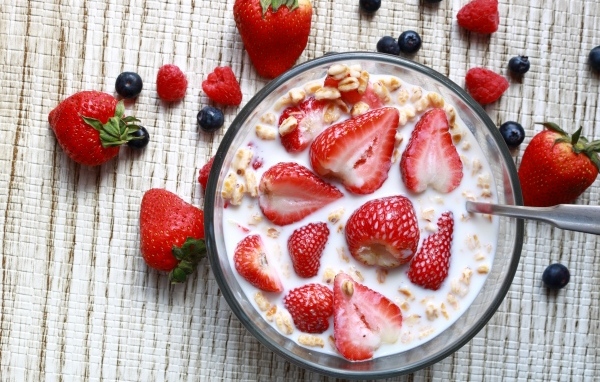 Овсянка с молоком в тарелке с ягодами малины