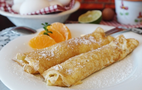 Блина на тарелке с дольками апельсина