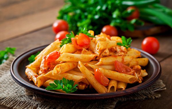 Макароны на тарелке с помидорами и петрушкой