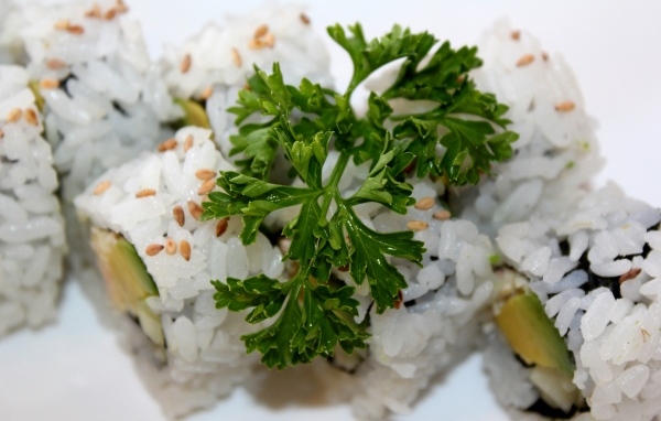 Роллы на тарелке с веточкой петрушки