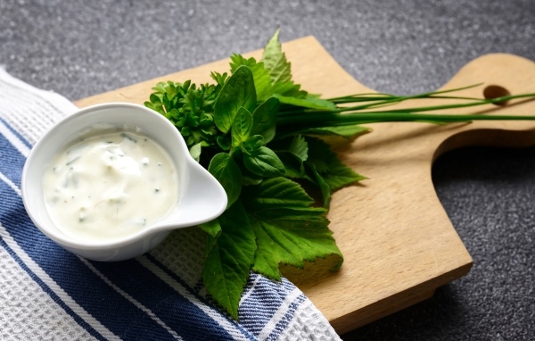 Соус с зеленью на деревянной доске 