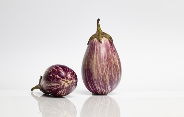 Два баклажана на сером фоне