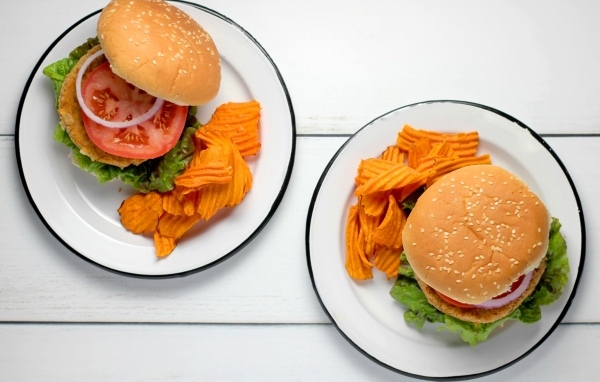 Два гамбургера на тарелке с чипсами