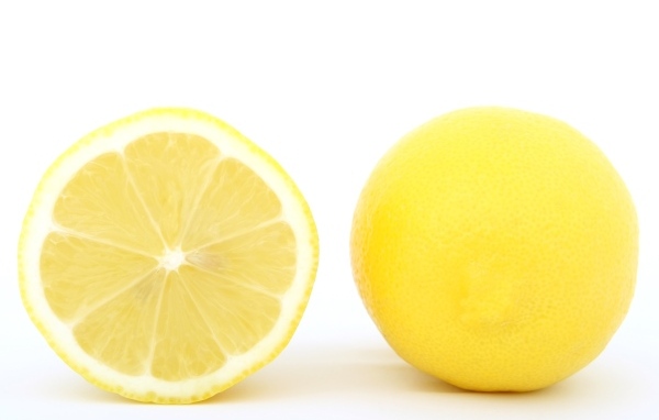 Большой желтый спелый лимон на белом фоне