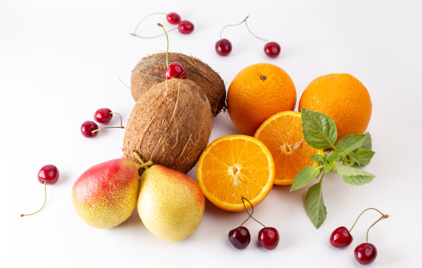 Кокосы, груши, апельсины и черешня на белом фоне