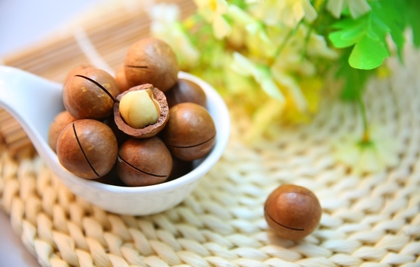 Орехи макадамия на столе с цветами