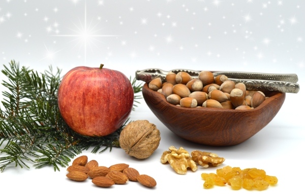 Орехи с яблоком и еловой веткой на столе