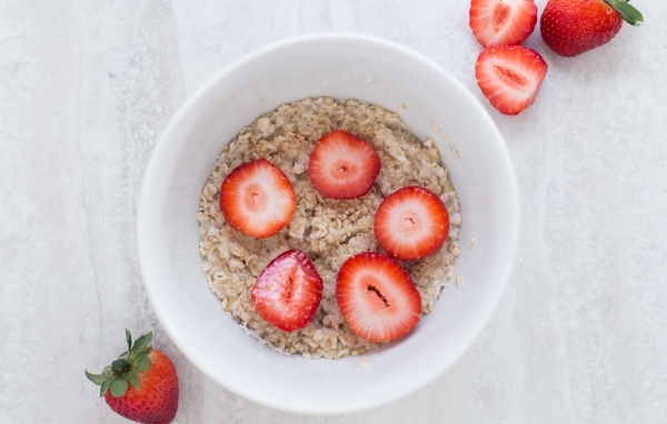 Овсяная каша с клубникой в белой тарелке 