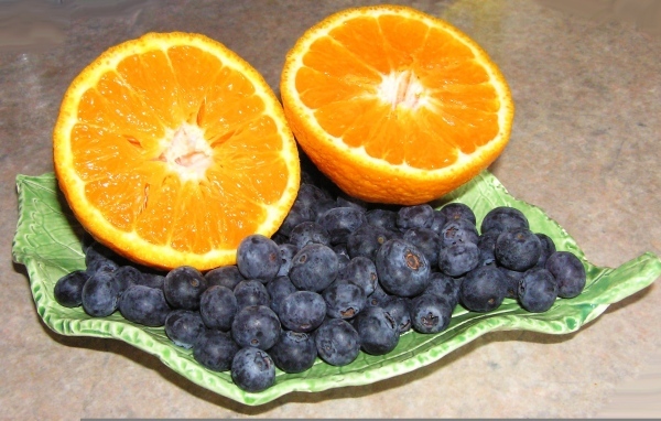 Половинки апельсина с ягодами черники на столе