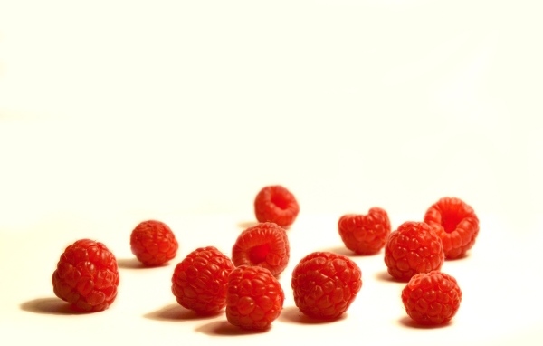 Красные ягоды малины на белом фоне крупным планом