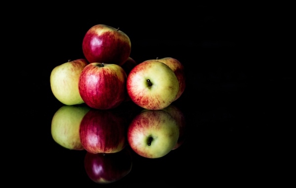 Спелые красные яблоки на черном фоне