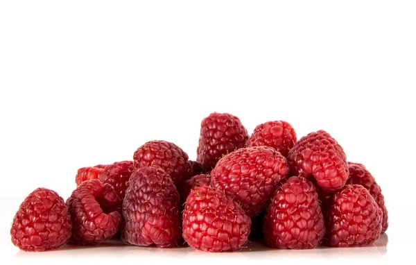 Спелые красные ягоды малины на белом фоне