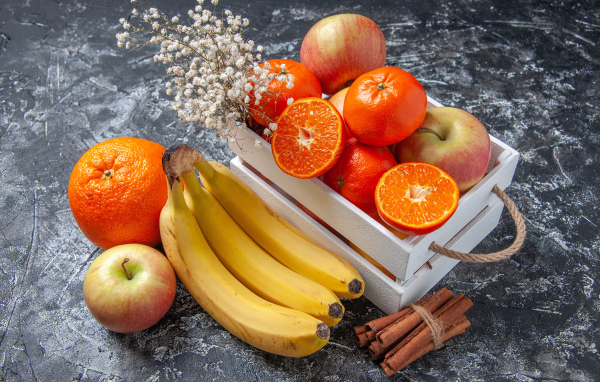 Спелые вкусные фрукты в ящике на столе