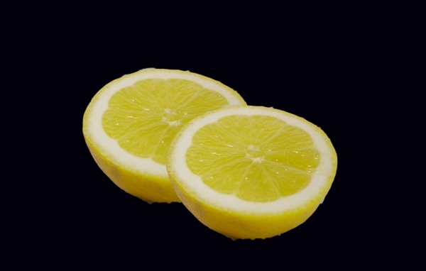 Две половинки лимона на черном фоне