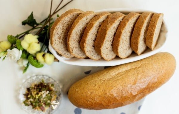 Батон нарезанный на столе с цветами