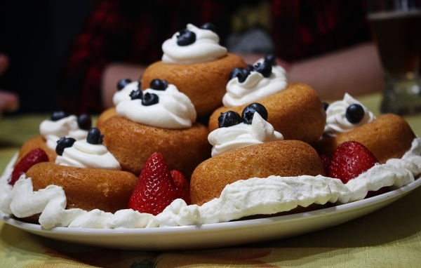 Пирожные на тарелке со взбитыми сливками и ягодами