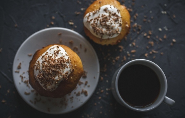 Пирожное в тертым шоколадом на столе с чашкой кофе