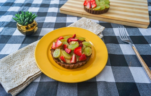 Пирожное с кремом и ягодами клубники и винограда