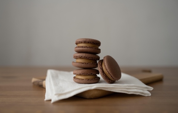 Шоколадный десерт макаронс на столе с салфеткой