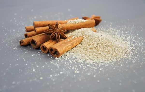 Корица с сахаром на сером фоне