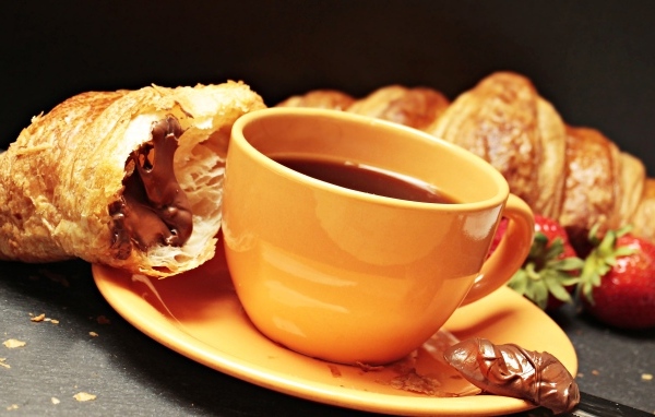 Чашка кофе на тарелке с круассанами