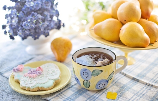 Чашка чая на столе с грушами и печеньем