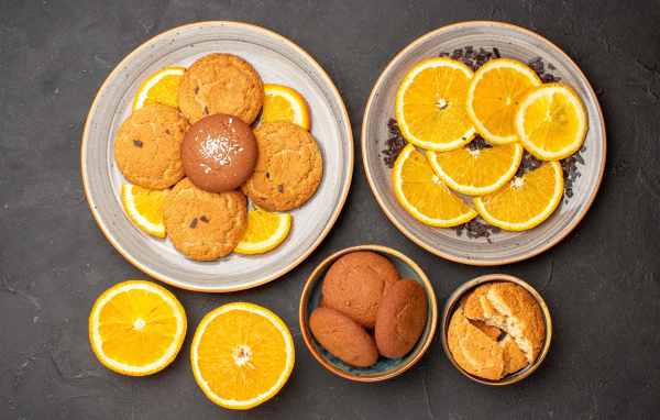 Вкусное печенье на тарелке с апельсинами