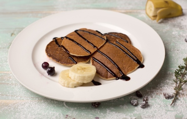 Оладьи на большой белой тарелке с бананами