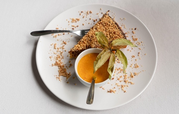 Кусок торта на белой тарелке с соком 