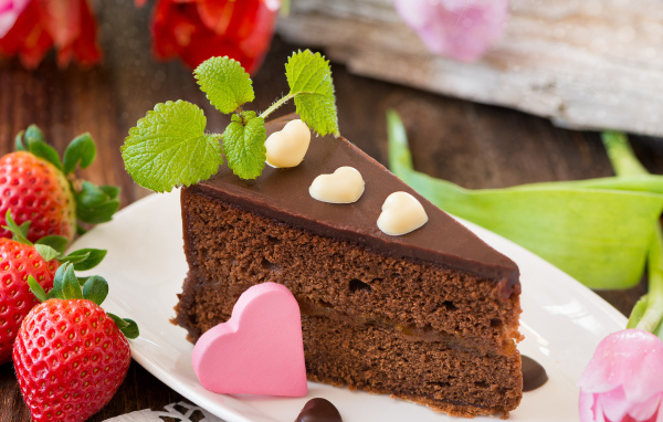 Кусок шоколадного торта с клубникой и сердечком