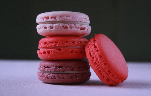 Розовый десерт макарон на столе 
