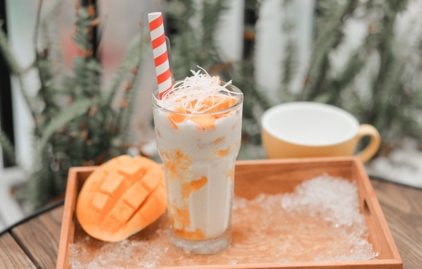 Коктейль с манго в стакане на столе