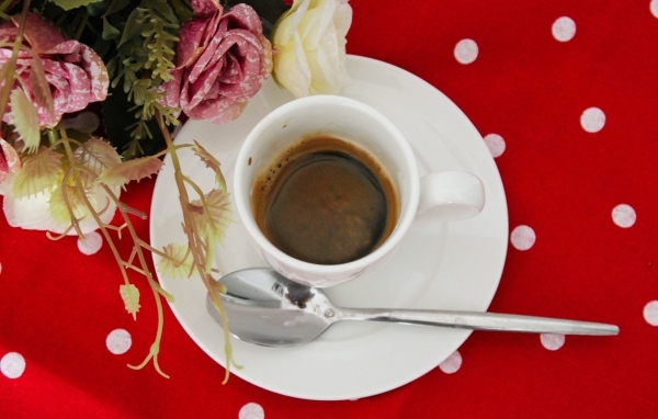 Чашка кофе на столе с цветами розы