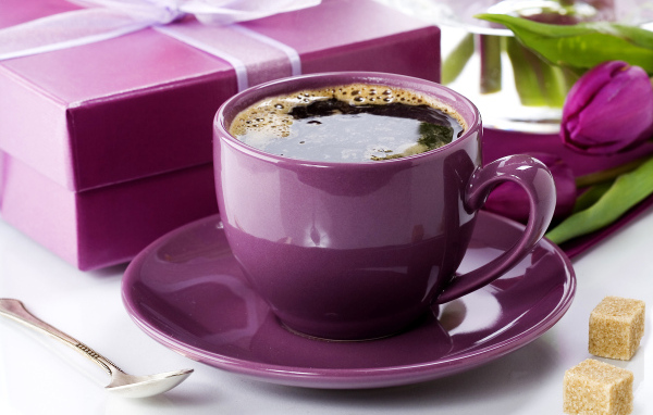 Чашка кофе с подарками и цветами на столе