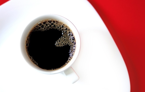 Чашка горячего черного кофе на столе 