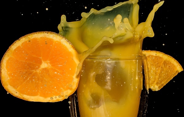 Свежий апельсиновый сок на черном фоне