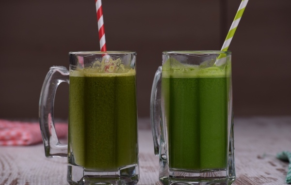 Два стакана зеленого смузи с трубочками