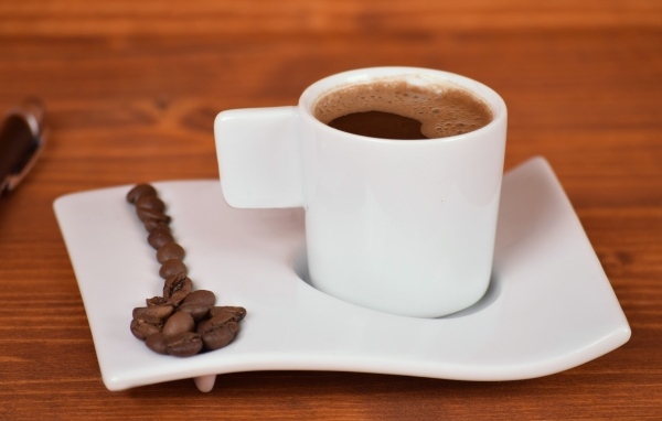 Белая чашка горячего кофе на столе 