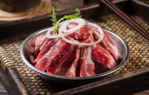 Свежие свиные ребра с луком в миске