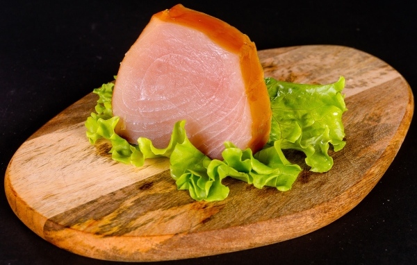 Кусок мяса с листом салата на доске