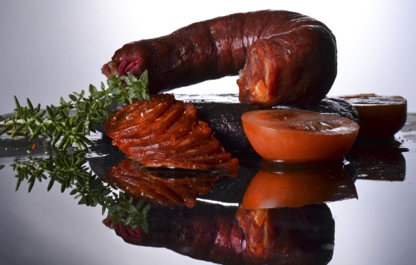 Колбаса с помидорами на зеркальном столе