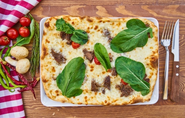 Мясная пицца с сыром и зелеными листьями