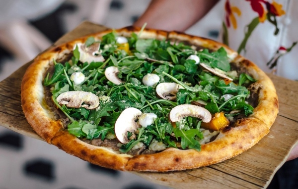 Пицца с грибами и листьями рукколы