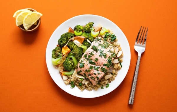 Вкусная рыба на тарелке с овощами и кашей