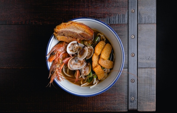 Суп с лапшой и морепродуктами на деревянном столе